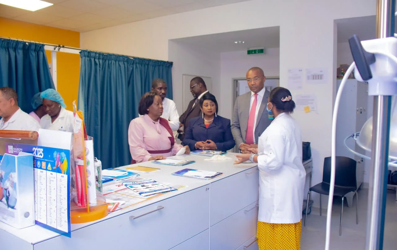Officials and nursing staff talking around a nurses’ station